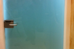 Drzwi wykonane ze szkła satynowego wykończone zamkiem i klamką